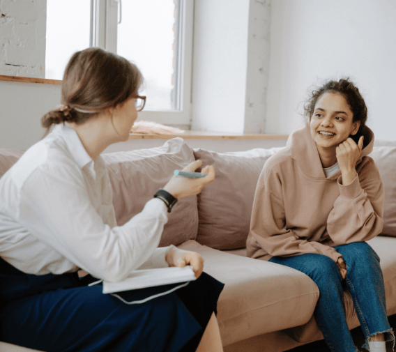 two women sitting on a sofa discussing pricing